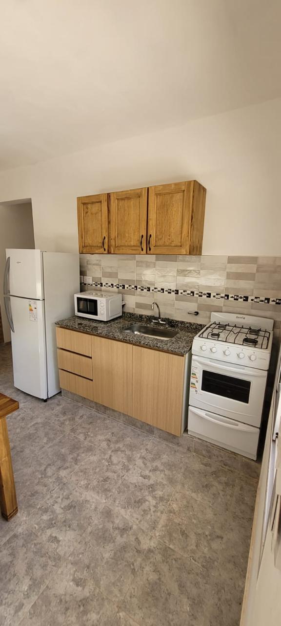 Cocina equipada con microondas y heladera